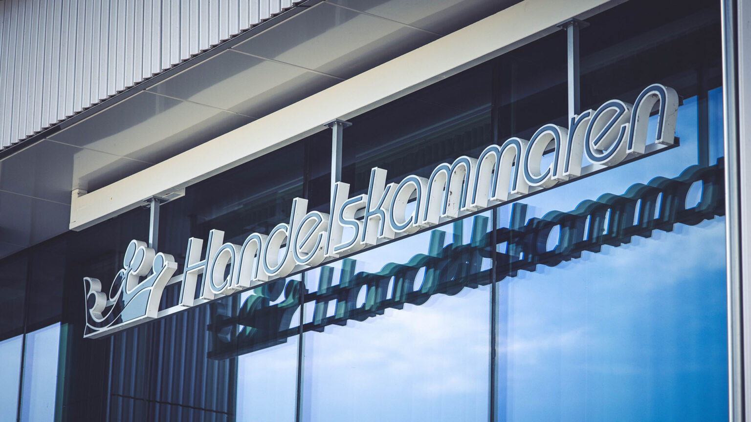 Bild på Östsvenska Handelskammarens logotyp hängandes på fasaden LINK Business Center.